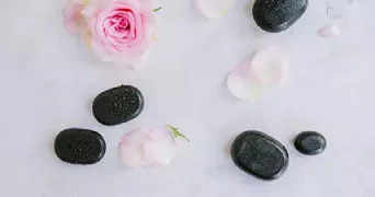 Czarne kamienie i płatki kwiatów